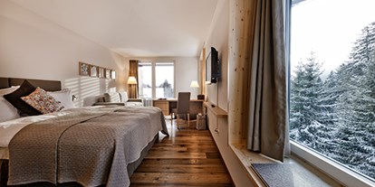 Hotels an der Piste - Skiservice: vorhanden - Schweiz - Doppelzimmer "Tgiasa da Lenn". Moderne Naturmaterialien, Erd-, Gras-, Holz- und Steinfarben im Innern verschmelzen mit der Gebirgswelt, die sich vor den grossen Fenstern auftut. Das alpine Design ist ehrlich und wertvoll zugleich – wie die Natur. - Valbella Resort