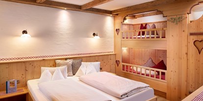 Hotels an der Piste - Ski-In Ski-Out - Dienten am Hochkönig - Schlafzimmer mit Doppelbett und Stockbett - Almdorf Flachau